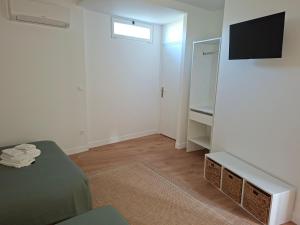 a white room with a bed and a mirror at Logis Hotel Restaurant Les Platanes in Aramon