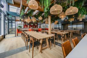 a restaurant with wooden tables and chairs and plants at The SPACE To Stay Aparthotel in St. Andrews +115 photos