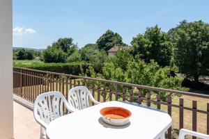 a white table and chairs on a balcony at Appartamento Posta del Lago in Passignano sul Trasimeno