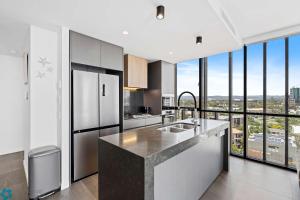 a kitchen with stainless steel appliances and large windows at Ocean View 3 Bedroom with Great Facilities - Hosted by Gold Coast Luxury Resorts in Gold Coast