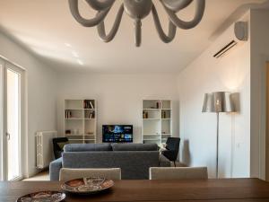 a living room with a couch and a chandelier at Casa Rita - Casa vacanze - free parking terrazze e giardino area barbecue TOP CLASS in Predore