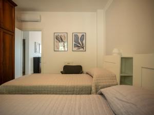 a bedroom with two beds and a chair at Casa Rita - Casa vacanze - free parking terrazze e giardino area barbecue TOP CLASS in Predore