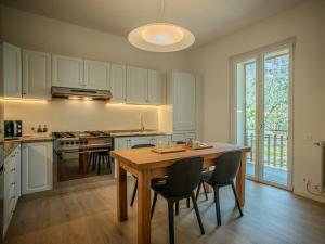 a large kitchen with a wooden table and chairs at Casa Rita - Casa vacanze - free parking terrazze e giardino area barbecue TOP CLASS in Predore