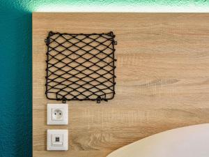 a wall with a wire mesh on it next to two outlets at hotelF1 Fréjus Roquebrune sur Argens in Roquebrune-sur-Argens
