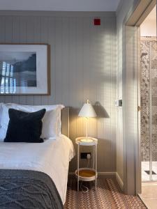 a bedroom with a bed and a table with a lamp at The Old Bell B&B in Grimston