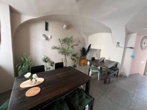 a dining room with a wooden table and a table and chairs at Cukrarna Guest Accommodation in Kranj
