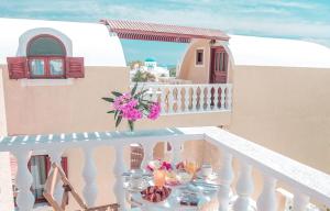 a table on a balcony with a vase of flowers at Villa Dima in Perissa