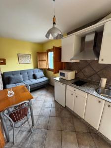 a kitchen and living room with a couch and a table at Apartamentos Cuevas del Mar in Nueva de Llanes +14 photos