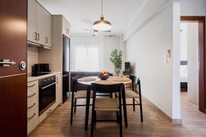 a kitchen with a table and chairs in a room at NIMA Mytikas Apartments - Aitoloakarnania in Mitika