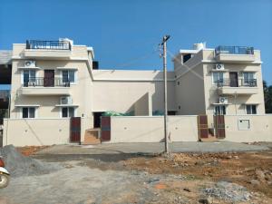 a large white building with balconies on top of it at Auro Green Villa in Pondicherry