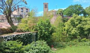 an old building with a tower on top of a garden at Logement entier RDC quartier historique Parthenay in Parthenay