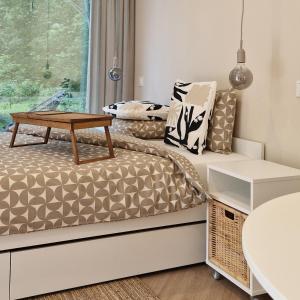 a small bedroom with a bed and a table at Poilsio nameliai TekaTeka in Anykščiai