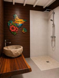 a bathroom with a stone sink on a wall at La Baie des Villas in Deshaies +59 photos