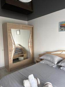 a bedroom with a bed with a mirror on the wall at Sun up Mamaia nord in Năvodari