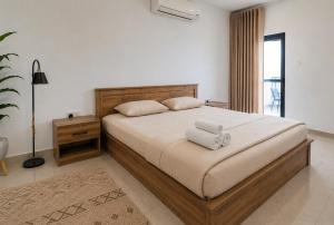 a bedroom with a bed with two towels on it at Cozy Apartment in Boshar in Muscat