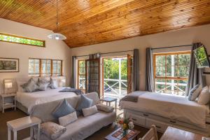 a living room with two beds and a couch at Lanherne Guest House Bed & Breakfast in Grahamstown