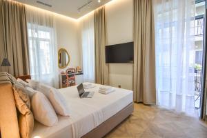 a bedroom with a bed with a laptop on it at Evilion Suites in Xylokastro