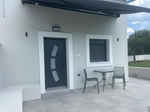 a patio with a table and two chairs and a door at Villa Ziglos by Karda Suites in Chios +4 photos