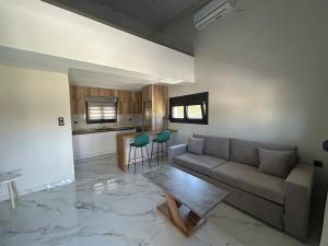a living room with a couch and a table and a kitchen at Villa Ziglos by Karda Suites in Chios