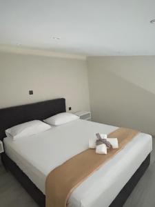 a bedroom with a large white bed with towels on it at Villa Ziglos by Karda Suites in Chios