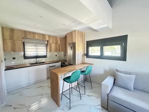 a kitchen with a table and two green chairs at Villa Ziglos by Karda Suites in Chios