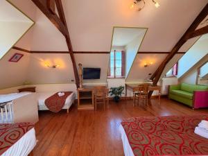 a hotel room with two beds and a television at Hôtel De Calais in Le Tréport