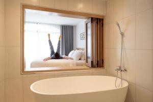a person is laying on a bed in a mirror at Taupe Hotel in Chiang Mai +69 photos