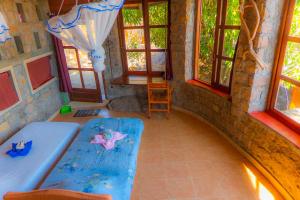a room with a table and a chair and windows at Tsarasoa Lodge in Ambalavao