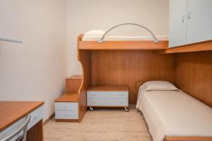 a small bedroom with a bunk bed and a desk at Casa Caorer by Sunhome Fiemme in Predazzo