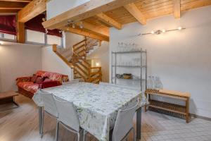 a dining room with a table and a couch at Casa Caorer by Sunhome Fiemme in Predazzo