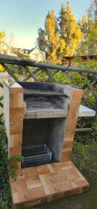 a outdoor fireplace with a wooden floor and a fence at Cabañas La Campiña Algarrobo in Algarrobo