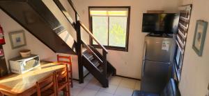 a kitchen with a refrigerator and a table with a microwave at Cabañas La Campiña Algarrobo in Algarrobo