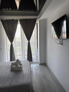 a bedroom with a bed and a large window at Sun up mamaia nord 2 in Năvodari
