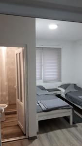 a bedroom with two beds and an open door at air&wizz II in Dubrave Gornje