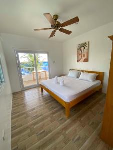 a bedroom with a bed with a ceiling fan at Beyond Island Resort in Moalboal +218 photos