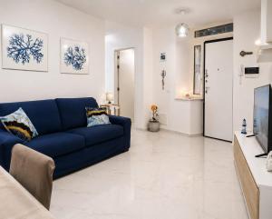 a living room with a blue couch and a tv at Casa Gimaga in Pozzuoli
