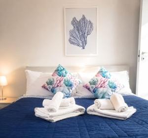 a bedroom with a blue bed with towels and pillows at Casa Gimaga in Pozzuoli