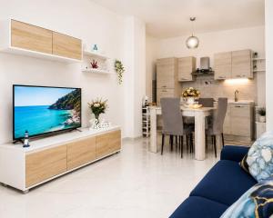a living room with a television and a dining room at Casa Gimaga in Pozzuoli
