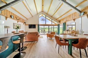 a living room with wooden ceilings and tables and chairs at Bwncath in Welshpool