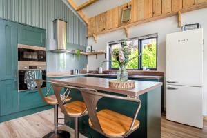 a kitchen with green cabinets and a table with chairs at Bwncath in Welshpool