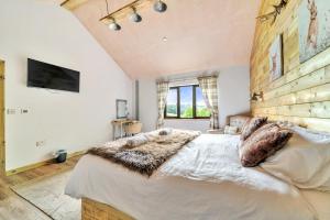 a bedroom with a large bed in a room with white walls at Bwncath in Welshpool