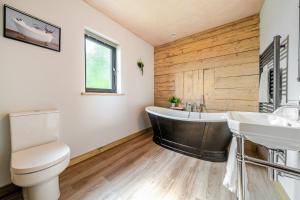 a bathroom with a tub and a toilet and a sink at Bwncath in Welshpool +36 photos