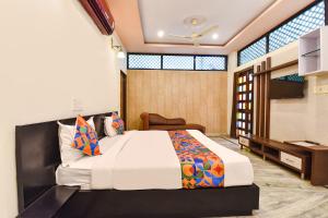 a bedroom with a large bed and a desk at FabHotel Moon Stone, Near Jawahar Circle - World Trade Park in Jaipur
