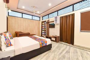 a hotel room with a bed and a window at FabHotel Moon Stone, Near Jawahar Circle - World Trade Park in Jaipur +22 photos