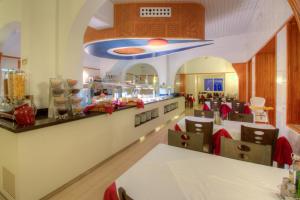 a restaurant with a table and chairs in a room at Hotel Roca Bella in Es Pujols