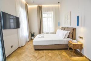 a bedroom with a bed and a television in it at Evilion Suites in Xylokastro