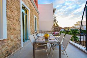 a patio with a table and chairs on a balcony at Evilion Suites in Xylokastro