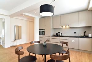 a kitchen and dining room with a table and chairs at SAXX Apartments Hagen in Hagen +57 photos