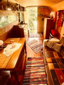 a living room with a table and a couch in a rv at Kuscheliger Zirkuswagen im Wildgarten in Witzenhausen +2 photos