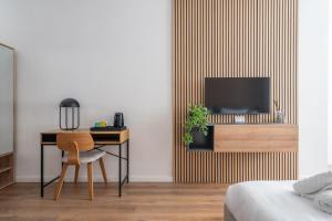 a bedroom with a desk and a tv on a wall at Slimiza in Sliema